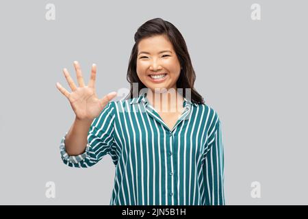 bonne femme asiatique montrant cinq doigts Banque D'Images