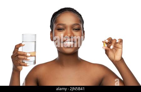 femme africaine avec de l'huile de foie de morue et du verre d'eau Banque D'Images