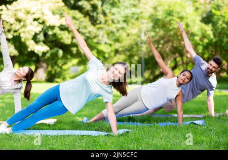 groupe de personnes faisant du yoga au parc d'été Banque D'Images
