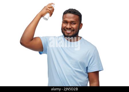 afro-américain homme appliquant un laque sur les cheveux Banque D'Images
