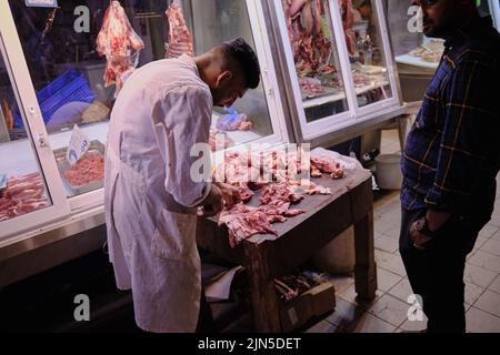 Boucher les morceaux de poulet préparés pour le client à l'intérieur du marché municipal central d'Athènes Banque D'Images