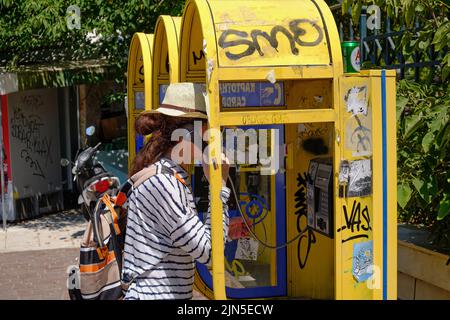 Femme utilisant un téléphone public dans le centre d'Athènes Banque D'Images