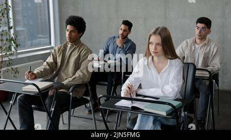 Les étudiants s'assoient à un bureau en classe Écoutez la conférence pendant le séminaire rédigez des notes Préparez-vous pour le public professionnel de l'examen des jeunes du groupe de conférence Banque D'Images