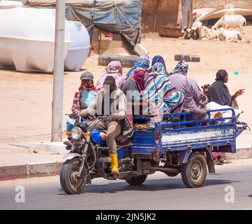 Un triple voyage en bas d'une rue transportant beaucoup de personnes. La ville est Nouakchott, Mauritanie. Banque D'Images