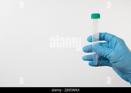 tube à vide pour le prélèvement et les échantillons de sang dans des gants bleus pour laboratoire. Sur fond blanc Banque D'Images