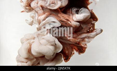L'encre colorée se répand dans l'eau sur fond blanc Banque D'Images