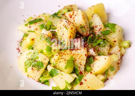 Salade de pommes de terre avec oignon vert sur plaque blanche sur fond de bois avec espace de copie. Vue de dessus, plat plat de la nourriture Banque D'Images