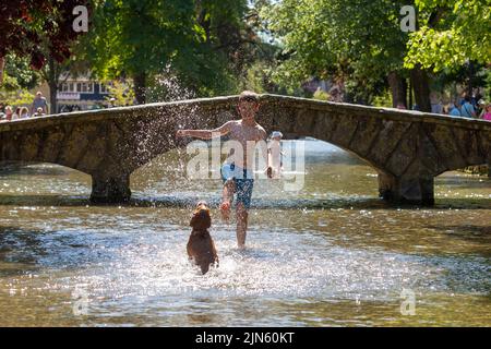 Bourton on the Water, Glocs, Royaume-Uni. 9th août 2022. Les gens sont à l'extérieur et à propos de profiter du soleil au bord de la rivière Windrush à Bourton on the Water, Glocestershire, car les températures sont sur le point d'augmenter cette semaine. Crédit : Peter Lophan/Alay Live News Banque D'Images