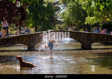 Bourton on the Water, Glocs, Royaume-Uni. 9th août 2022. Les gens sont à l'extérieur et à propos de profiter du soleil au bord de la rivière Windrush à Bourton on the Water, Glocestershire, car les températures sont sur le point d'augmenter cette semaine. Crédit : Peter Lophan/Alay Live News Banque D'Images