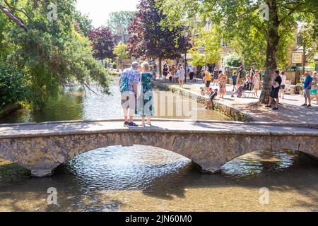 Bourton on the Water, Glocs, Royaume-Uni. 9th août 2022. Les gens sont à l'extérieur et à propos de profiter du soleil au bord de la rivière Windrush à Bourton on the Water, Glocestershire, car les températures sont sur le point d'augmenter cette semaine. Crédit : Peter Lophan/Alay Live News Banque D'Images