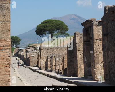 Visite touristique du site d'excavation de Pompéi avec le volcan Vesivius en arrière-plan. Pompei, Campanie, Italie Banque D'Images