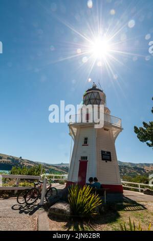 Un couple de cyclistes et leurs vélos garés au phare d'Akaroa Head à Akaroa, une ancienne colonie française dans la péninsule de Banks, île du Sud, Banque D'Images