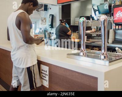 La femme commande le repas dans le menu du terminal à écran tactile électronique du restaurant fastfood Burger King Banque D'Images