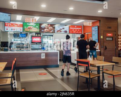 La femme commande le repas dans le menu du terminal à écran tactile électronique du restaurant fastfood Burger King Banque D'Images