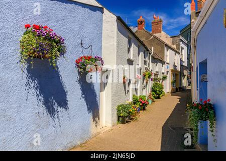 Une rangée de cottages colorés avec paniers suspendus à CoB Lane, Tenby, Pembrokeshire, pays de Galles, Royaume-Uni Banque D'Images