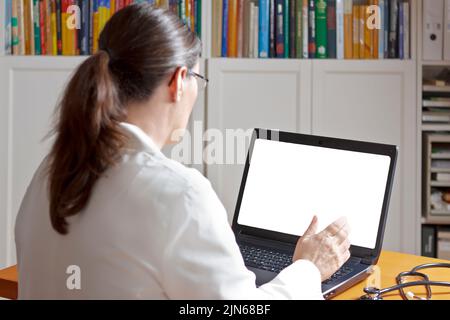 Maquette du concept de télémédecine : femme médecin ou pharmacien parlant devant un ordinateur portable avec un écran blanc vierge. Banque D'Images