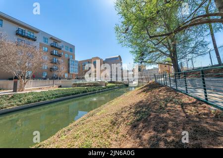 Petite rivière avec des passerelles sur le côté près des résidences urbaines à San Antonio, Texas Banque D'Images