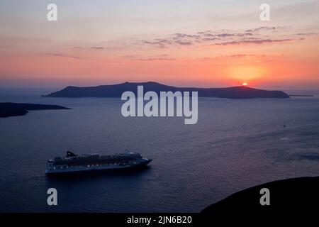 Vue sur le coucher de soleil de Santorini ou Fira à Santorini. Un bateau de croisière, le Norwegian Jade, est ancré dans le port. Banque D'Images