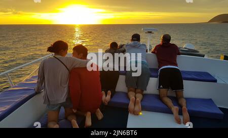 Un groupe de touristes regardant le coucher du soleil depuis un bateau, îles Galapagos, Equateur Banque D'Images