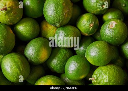 Citrons verts placés sur une étagère pour la vente sur un marché Banque D'Images