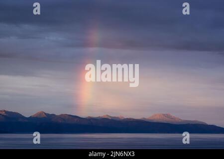 Arc-en-ciel au premier feu au-dessus des montagnes Kenai à travers la baie de Kachemak depuis Homer dans le centre-sud de l'Alaska. Banque D'Images