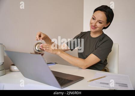 Une jeune femme se verse une tasse de thé Banque D'Images