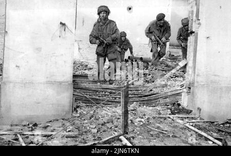 st action photo des forces britanniques d'Airbourne en Hollande -- Une patrouille de parachutistes britanniques à la recherche d'une maison en ruines à Costerbeck. Quand le 1st., allié le 1st. L'armée Allied Airbourne a été abandonnée en Hollande, les photographes de l'unité de film et de photographie de l'Armée étaient avec eux. Il s'agit de l'une des premières photos reçues. Un des photographes écrit dans une lettre datée du 20th septembre., « c'est le quatrième jour si la lutte contre un travail d'appareil photo est presque de la question. Toute la journée, nous avons été sous le feu de obus, de mortes et de machines. 27 septembre 1944. (Photo par British Official Photograph). Banque D'Images