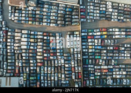 Vue aérienne du grand parking de junkyard avec des rangées de voitures brisées jetées. Recyclage des vieux véhicules Banque D'Images