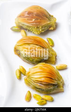 Baklava Midye turque ( Baklava en forme de mussel ) avec poudre de pistache verte et crème au beurre. Conceptuel des fêtes islamiques. Banque D'Images