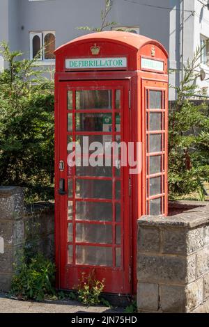 téléphone rouge britannique traditionnel servant à loger un défibrillateur dans une rue de st leonards, hastings, téléphone rouge réaffecté ou pupitre d'appel. Banque D'Images