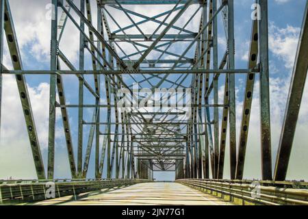 Traversée d'un pont de treillis routier à travées multiples au-dessus d'une rivière avec ciel bleu nuageux Banque D'Images