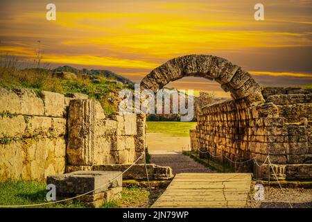 Entrée au stade - murs de pierre et arche entrant dans le champ où les premiers jeux de l'HAP hellénique ont eu lieu à Olympia Grèce au coucher du soleil. Banque D'Images