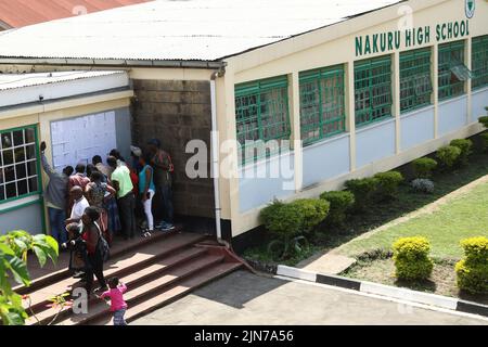 Nakuru, Kenya. 09th août 2022. Les électeurs tentent de localiser leur nom sur la liste des électeurs épinglée sur un conseil d'administration à la station de vote de l'école secondaire Nakuru Boys dans la circonscription de Nakuru Town East pendant l'élection générale du Kenya. Les Kenyans ont commencé à voter mardi matin, 9 août 2022, pour élire leur président préféré et les membres des parlements nationaux et locaux. Crédit : SOPA Images Limited/Alamy Live News Banque D'Images