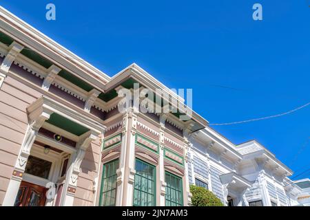 Maisons avec extérieur de style victorien de la reine anne dans une vue à angle bas contre le ciel bleu clair. Il y a une maison sur la gauche avec des panneaux latéraux en vinyle être Banque D'Images