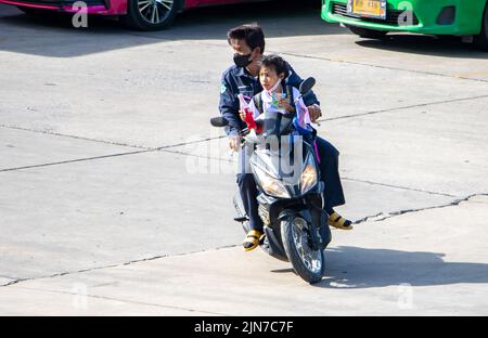 SAMUT PRAKAN, THAÏLANDE, JUIN 09 2022, Un père à bord d'une moto avec une fille en uniforme scolaire Banque D'Images