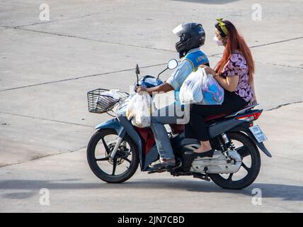 SAMUT PRAKAN, THAÏLANDE, JUIN 09 2022, Un chauffeur de taxi sur une moto se déplace avec une femme à l'achat. Banque D'Images