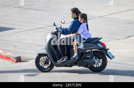 SAMUT PRAKAN, THAÏLANDE, JUIN 09 2022, Une mère à bord d'une moto avec une fille en uniforme scolaire Banque D'Images
