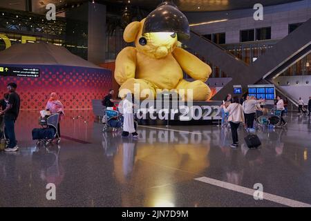 Hall des départs de l'aéroport international de Hamad, Doha, Qatar, la nuit, montrant la statue de l'ours-lampe de l'artiste suisse Urs Fischer et # Qatar 2022 Banque D'Images