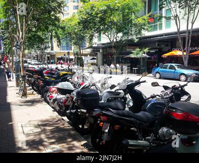 Rue urbaine avec motos garées d'un côté et à louer vélos et voitures de l'autre à Brisbane Queensland Australie nov 21 2013 Banque D'Images