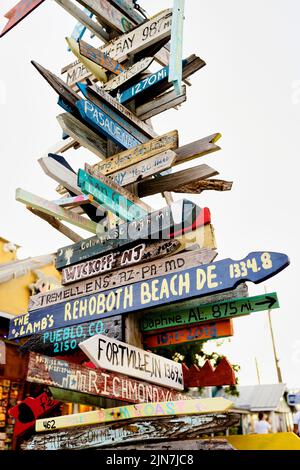 Panneau directionnel à Key West, Florida, FL, USA. Flèches de distance directionnelles peintes à la main Banque D'Images