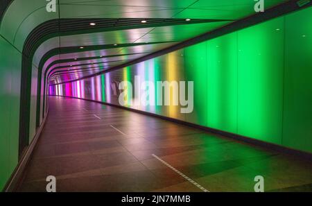 Un tunnel éclairé par des lumières colorées en direction du métro aux stations Kings Cross et St Pancras Banque D'Images