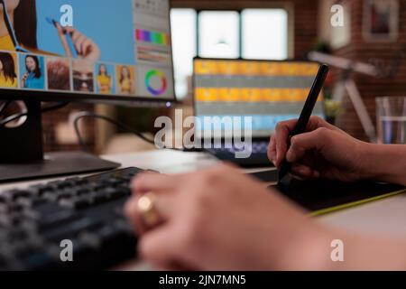 Éditeur féminin utilisant un stylet sur une tablette graphique pour retoucher des photos, créant ainsi du contenu photographique professionnel pour la production. Montage indépendant de l'image avec logiciel de retouche créatif. Gros plan. Banque D'Images