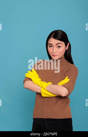 Triste malheureux malheureux et stressé femme de ménage asiatique Cross main Angry yeux avec l'expression du visage portant des gants jaunes, concept de nettoyage à la maison, fatigué frustré femme avec l'état d'esprit négatif Banque D'Images