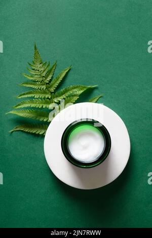 Concept de spa ou de produits cosmétiques avec des ingrédients naturels décoré de fougères fraîches sur fond vert. Format vertical. Vue de dessus. Banque D'Images