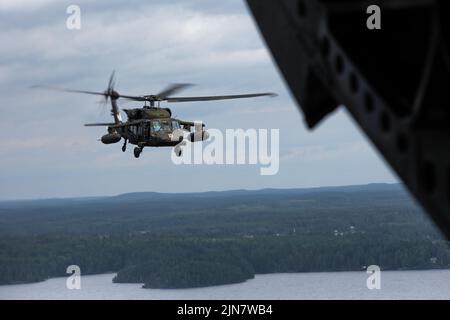 Une Armée américaine UH-60 Black Hawk, affectée au 1st Escadron, 214th General support Aviation Battalion, 12th combat Aviation Brigade, vole derrière un CH-47 Chinook lors d'un vol culturel d'échange tenu à Tampere, Finlande, le 4 août 2022. Au cours des prochaines semaines, les soldats américains et les troupes finlandaises effectueront de multiples exercices d'entraînement pour renforcer les relations et aider à établir l'interopérabilité entre les deux nations. (É.-U. Photo de la Garde nationale de l'armée par le Sgt. Agustín Montañez) Banque D'Images