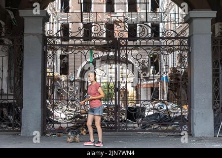 Kharkiv, Ukraine. 01st août 2022. Une jeune femme avec un chien vu près de l'entrée de la cour d'une maison endommagée. Bâtiment détruit dans le centre-ville historique de Kharkiv, Ukraine - 1 août 2022 (photo de Mykhaylo Palinchak/SOPA Images/Sipa USA) crédit: SIPA USA/Alay Live News Banque D'Images