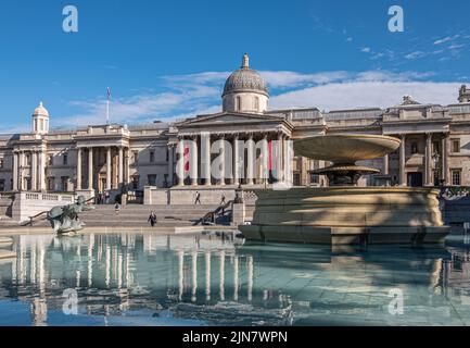 Londres, Royaume-Uni- 4 juillet 2022 : Trafalgar Square. Bâtiment de la Galerie nationale avec dôme, fronton et colonnes partiellement reflétées dans la fontaine sous bleu cl Banque D'Images