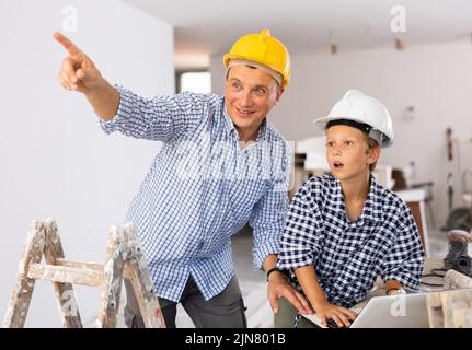 Père et fils parlant de travaux d'amélioration de la maison dans l'appartement Banque D'Images