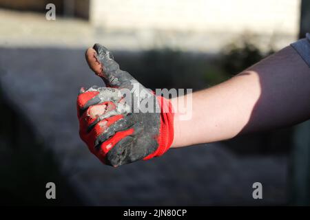 Effet de flou artistique. Porter des gants sales et étanches. Ouvrir les mains dans des gants de travail usés, protection contre les dommages pendant le fonctionnement, gros plan Banque D'Images