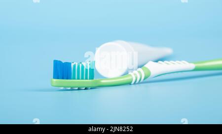 brosse à dents et dentifrice sur fond bleu, soins dentaires. Banque D'Images